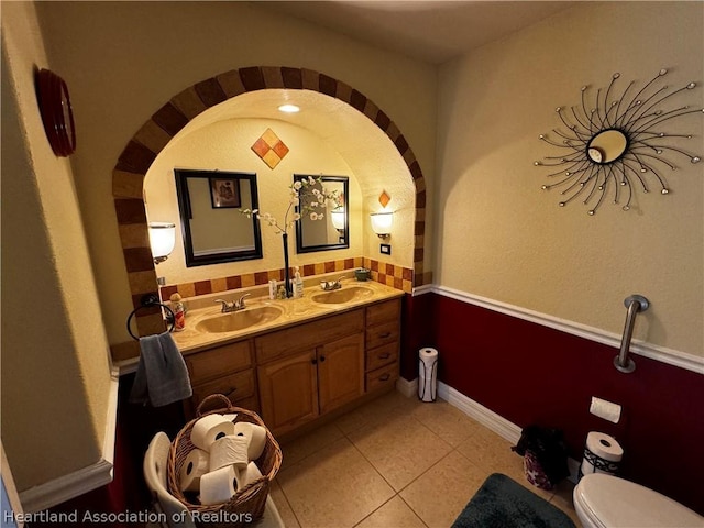 bathroom with tile patterned flooring, vanity, and toilet