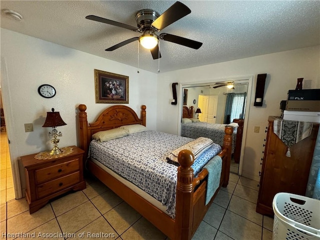 tiled bedroom with a textured ceiling, a closet, and ceiling fan