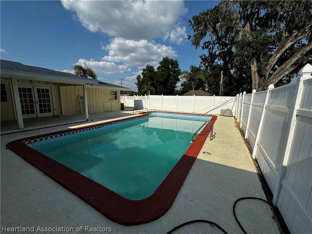 view of swimming pool featuring a patio and french doors