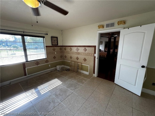 tiled empty room with ceiling fan