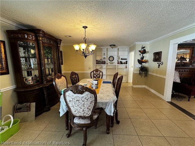 dining room with built in shelves, a textured ceiling, crown molding, light tile patterned floors, and a notable chandelier