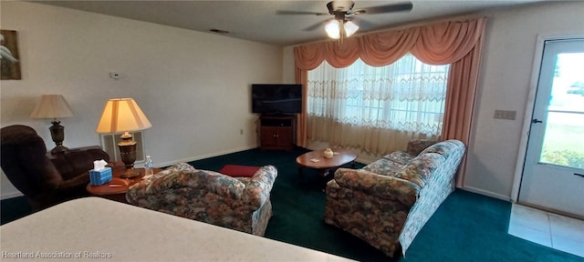 living room featuring a ceiling fan, a wealth of natural light, visible vents, and baseboards