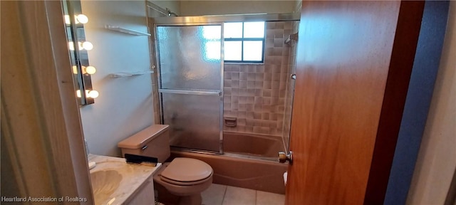 bathroom with toilet, tile patterned flooring, combined bath / shower with glass door, and vanity