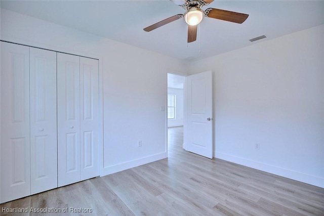 unfurnished bedroom featuring ceiling fan, a closet, and light hardwood / wood-style flooring