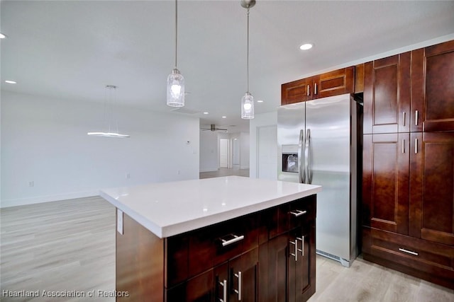 kitchen with stainless steel refrigerator with ice dispenser, light wood-type flooring, ceiling fan, decorative light fixtures, and a center island