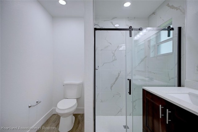 bathroom featuring toilet, a shower with door, vanity, and hardwood / wood-style flooring