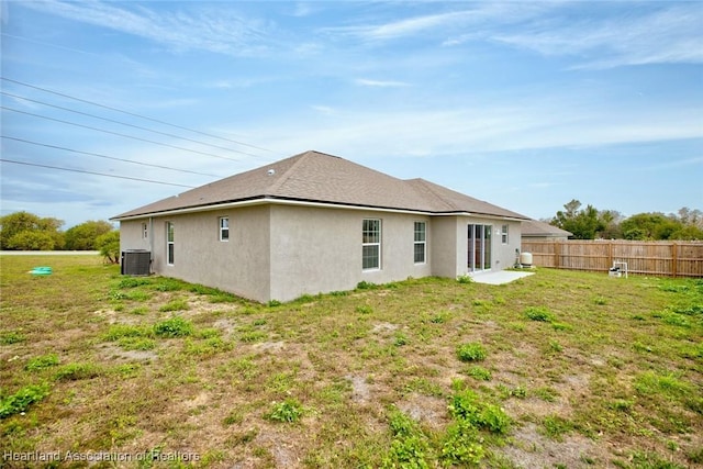 rear view of house with a yard and cooling unit