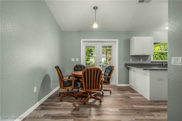 dining space with sink, dark wood-type flooring, and french doors