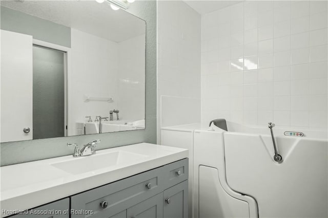 bathroom featuring vanity and a tub to relax in