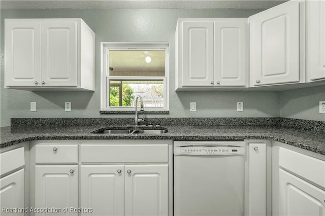 kitchen with dishwasher, white cabinets, dark stone countertops, and sink