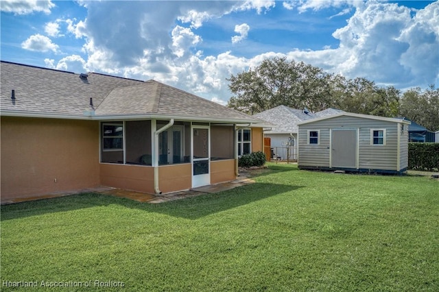 rear view of property with a sunroom, a storage shed, and a lawn