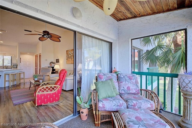 sunroom featuring a sink, ceiling fan, and vaulted ceiling