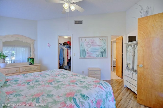 bedroom featuring wood finished floors, visible vents, ceiling fan, a spacious closet, and a closet