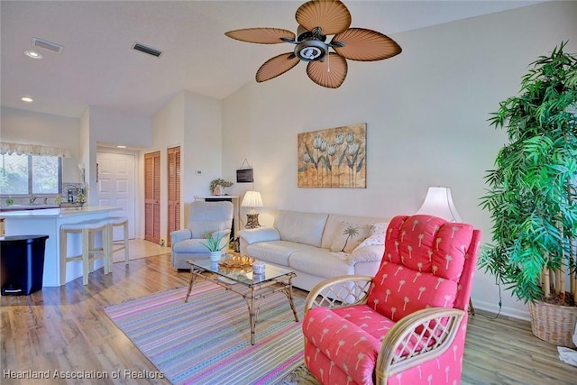 living room with visible vents, a ceiling fan, and light wood-type flooring