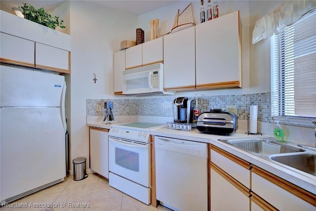 kitchen with white appliances, white cabinetry, tasteful backsplash, and light countertops