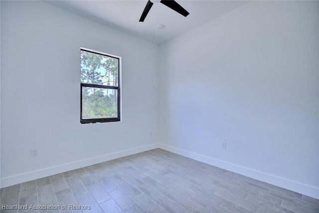 unfurnished room with ceiling fan, light wood-style flooring, and baseboards