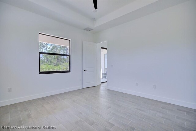 spare room featuring light wood-style flooring and baseboards