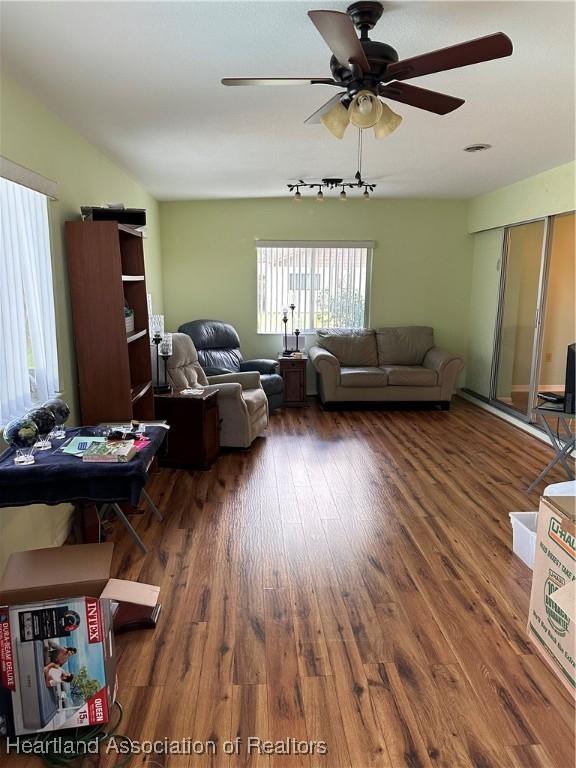 living room featuring dark hardwood / wood-style flooring and ceiling fan