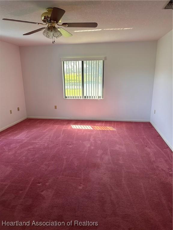 carpeted spare room featuring ceiling fan