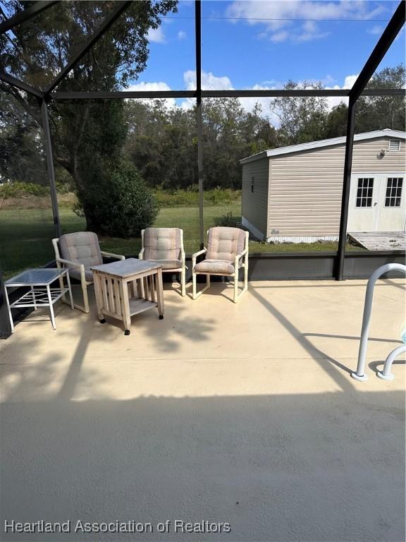 view of patio / terrace with glass enclosure and an outbuilding