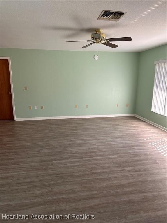 spare room with a textured ceiling, dark hardwood / wood-style floors, and ceiling fan