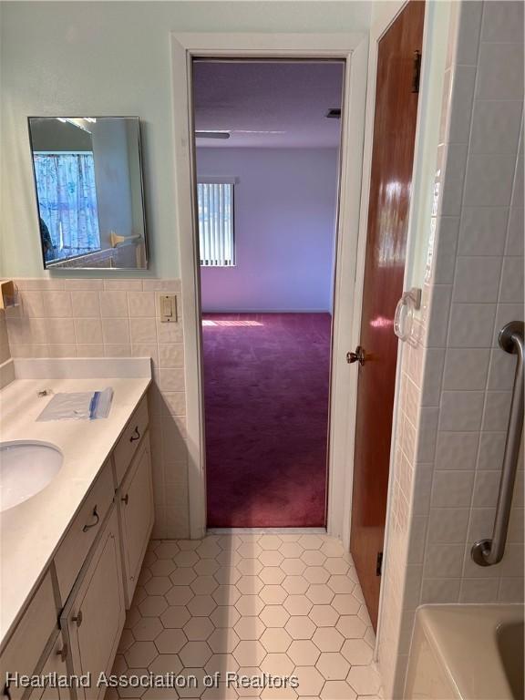 bathroom with tile patterned flooring, vanity, and tile walls