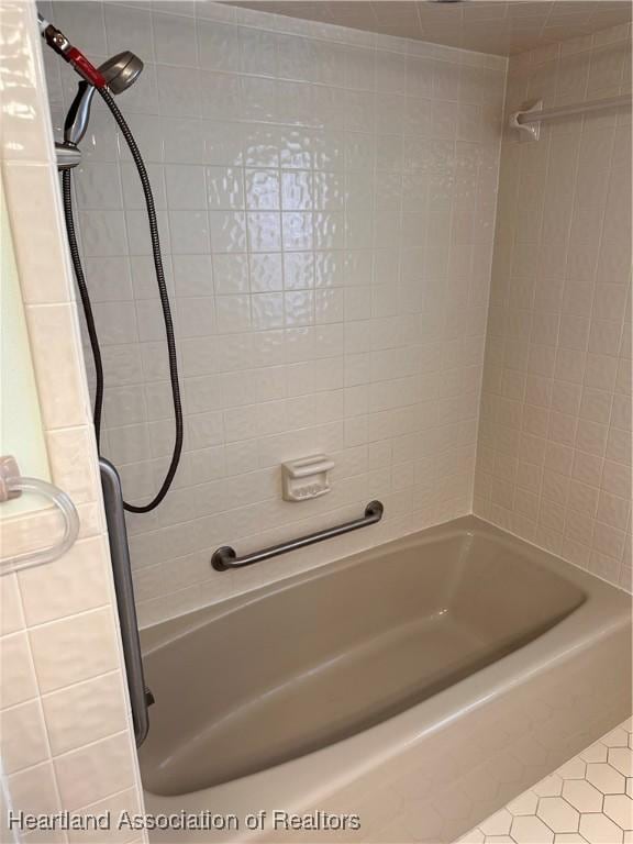 bathroom featuring tile patterned flooring and tiled shower / bath combo