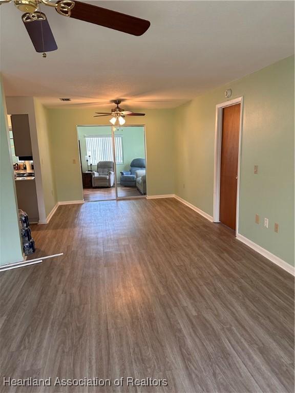 unfurnished living room with dark wood-type flooring