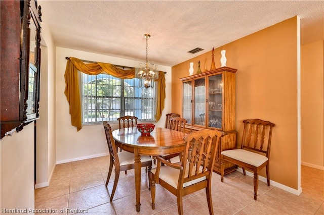 dining room with light tile patterned floors, a textured ceiling, and an inviting chandelier