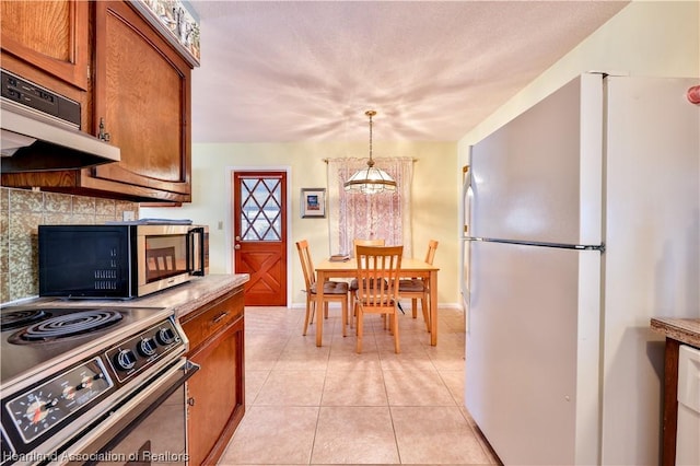 kitchen with an inviting chandelier, light tile patterned floors, decorative light fixtures, and appliances with stainless steel finishes