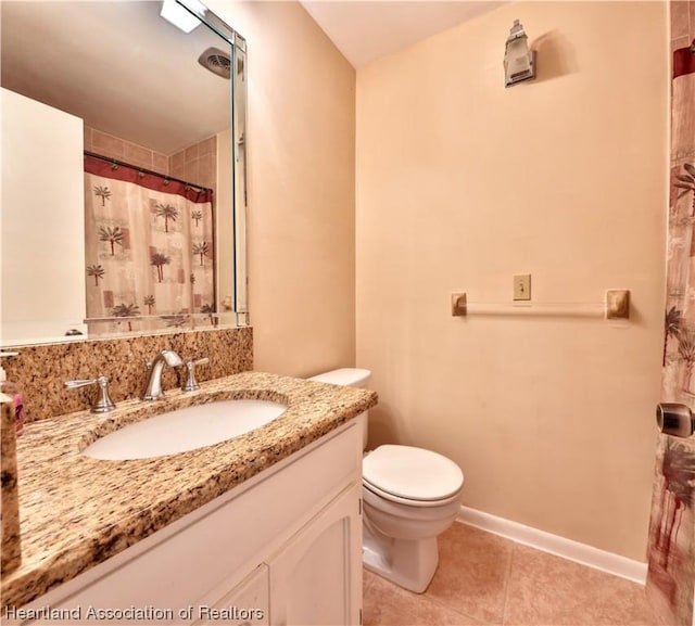 bathroom featuring tile patterned flooring, vanity, toilet, and curtained shower