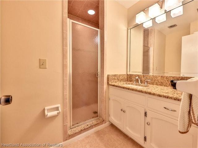 bathroom featuring vanity, tile patterned floors, and a shower with shower door