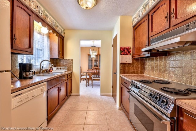 kitchen featuring dishwasher, stainless steel range with electric cooktop, sink, light tile patterned floors, and decorative light fixtures