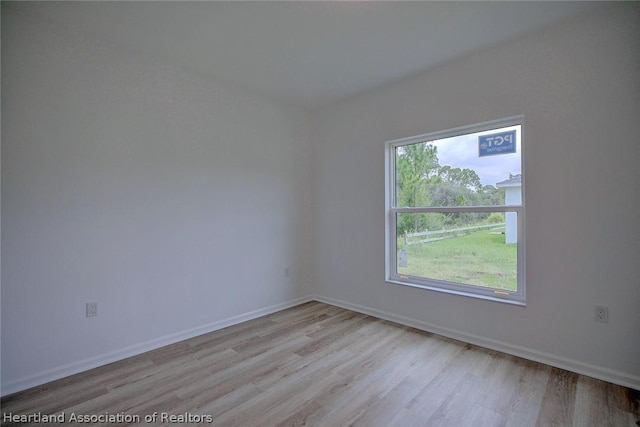 empty room with plenty of natural light and light hardwood / wood-style floors