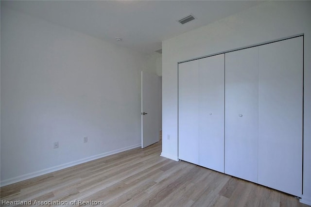 unfurnished bedroom featuring light wood-type flooring and a closet