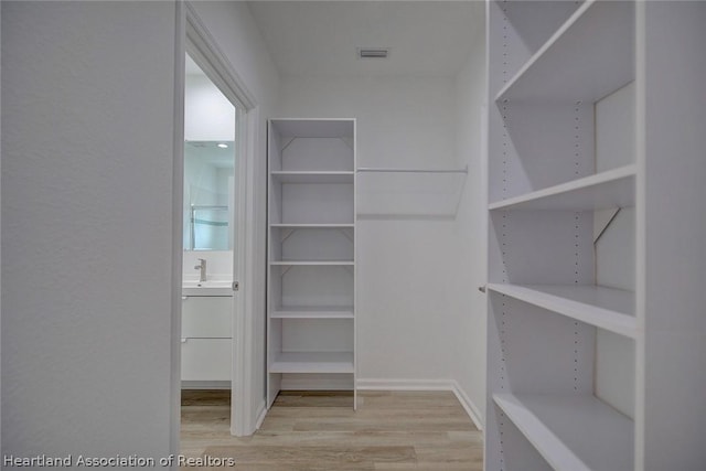 spacious closet featuring hardwood / wood-style flooring