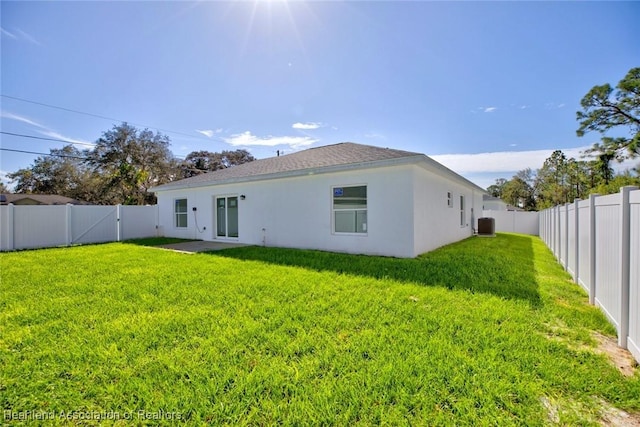 back of property featuring a lawn and cooling unit