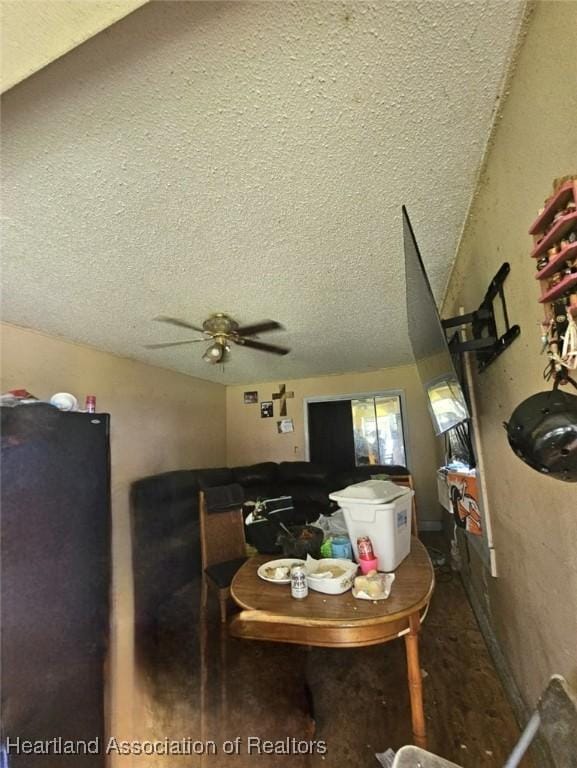 dining area with ceiling fan and a textured ceiling