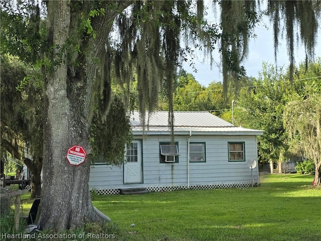 view of home's exterior featuring cooling unit and a lawn