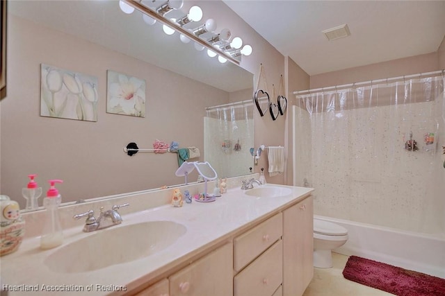 full bath featuring toilet, double vanity, a sink, and visible vents