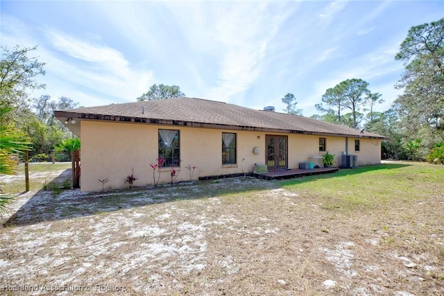 back of house with a lawn, cooling unit, and stucco siding