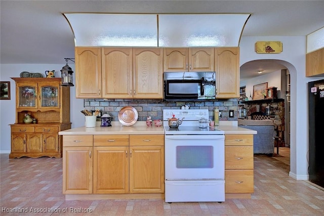 kitchen with arched walkways, white range with electric cooktop, light countertops, backsplash, and light brown cabinets