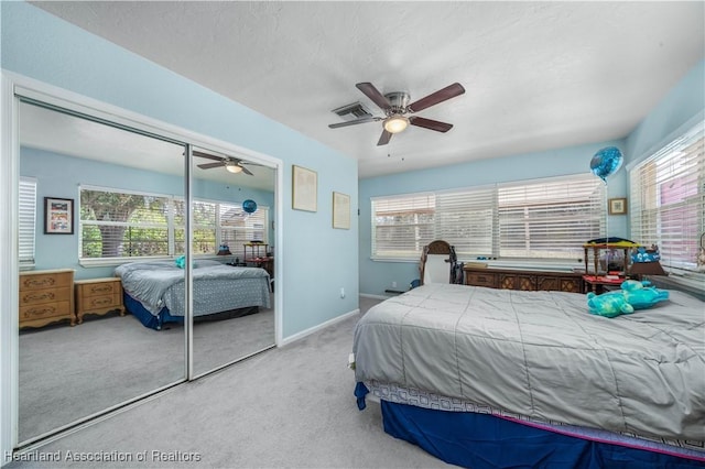 carpeted bedroom with multiple windows, a closet, and ceiling fan