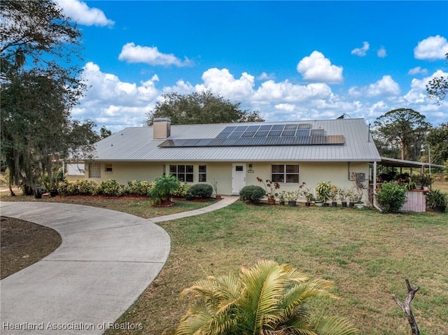 back of house with a lawn and solar panels