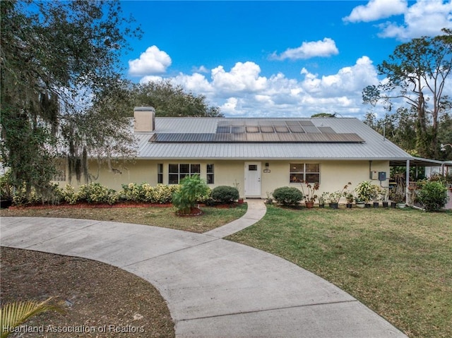 view of front of house featuring a front lawn and solar panels