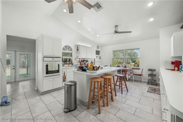 kitchen featuring white appliances, a healthy amount of sunlight, and white cabinets