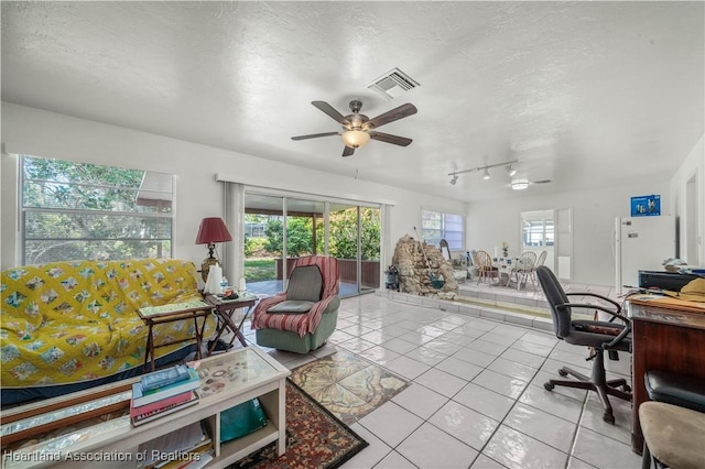 office with plenty of natural light, light tile patterned floors, and a textured ceiling