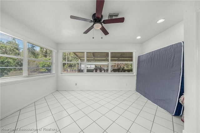 unfurnished sunroom featuring ceiling fan and a wealth of natural light