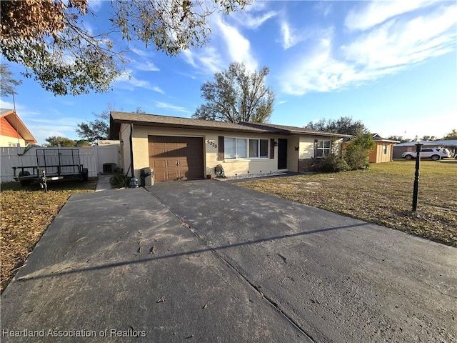 ranch-style home featuring a garage and central AC unit