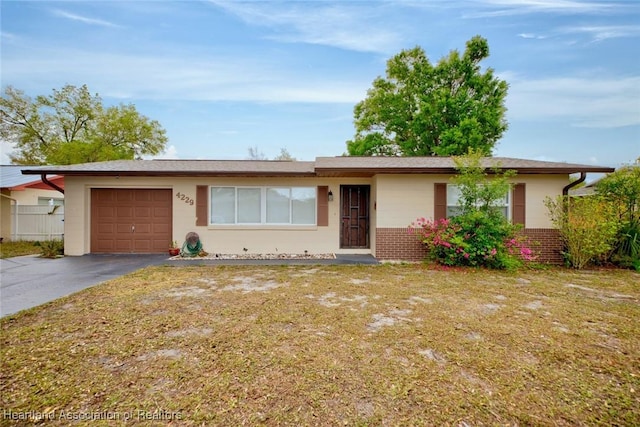 ranch-style home featuring brick siding, driveway, a front lawn, and a garage